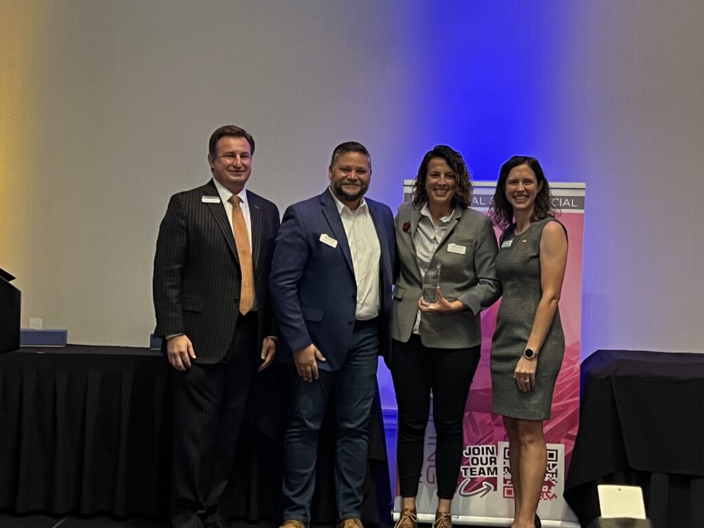 Solcium Solar Owners, Michelle and Gustavo, pose with their award for "2022 Best Large Business" with two members of the Seminole County Chamber of Commerce.