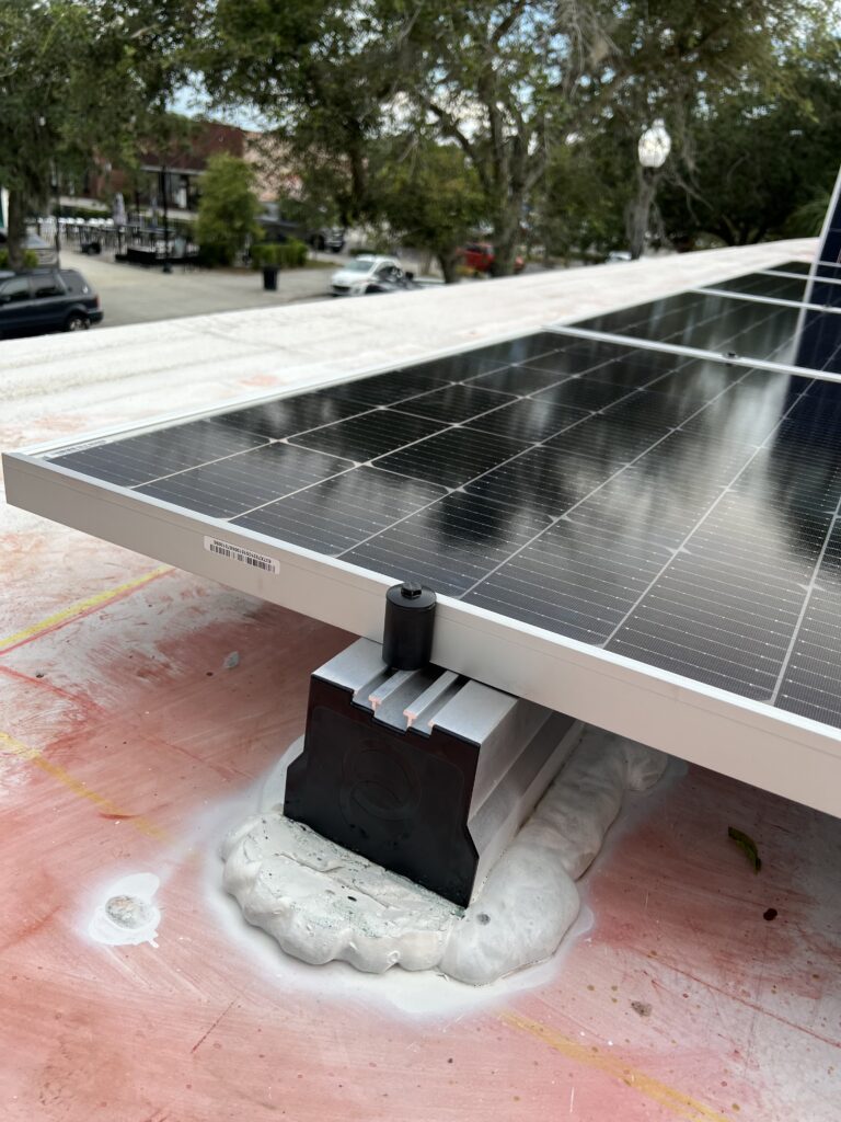 Close up image of Solar Stack product on cement rooftop with solar panel installed on top of it. 