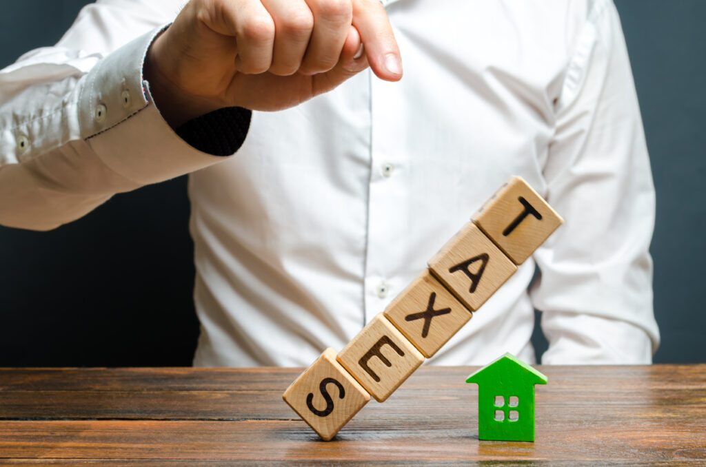 Business man pushes down a set of blocks representing taxes decreasing after a commercial solar investment