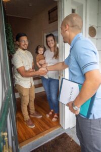 Solcium Solar employee meets smiling homeowner at doorstep with a friendly handshake