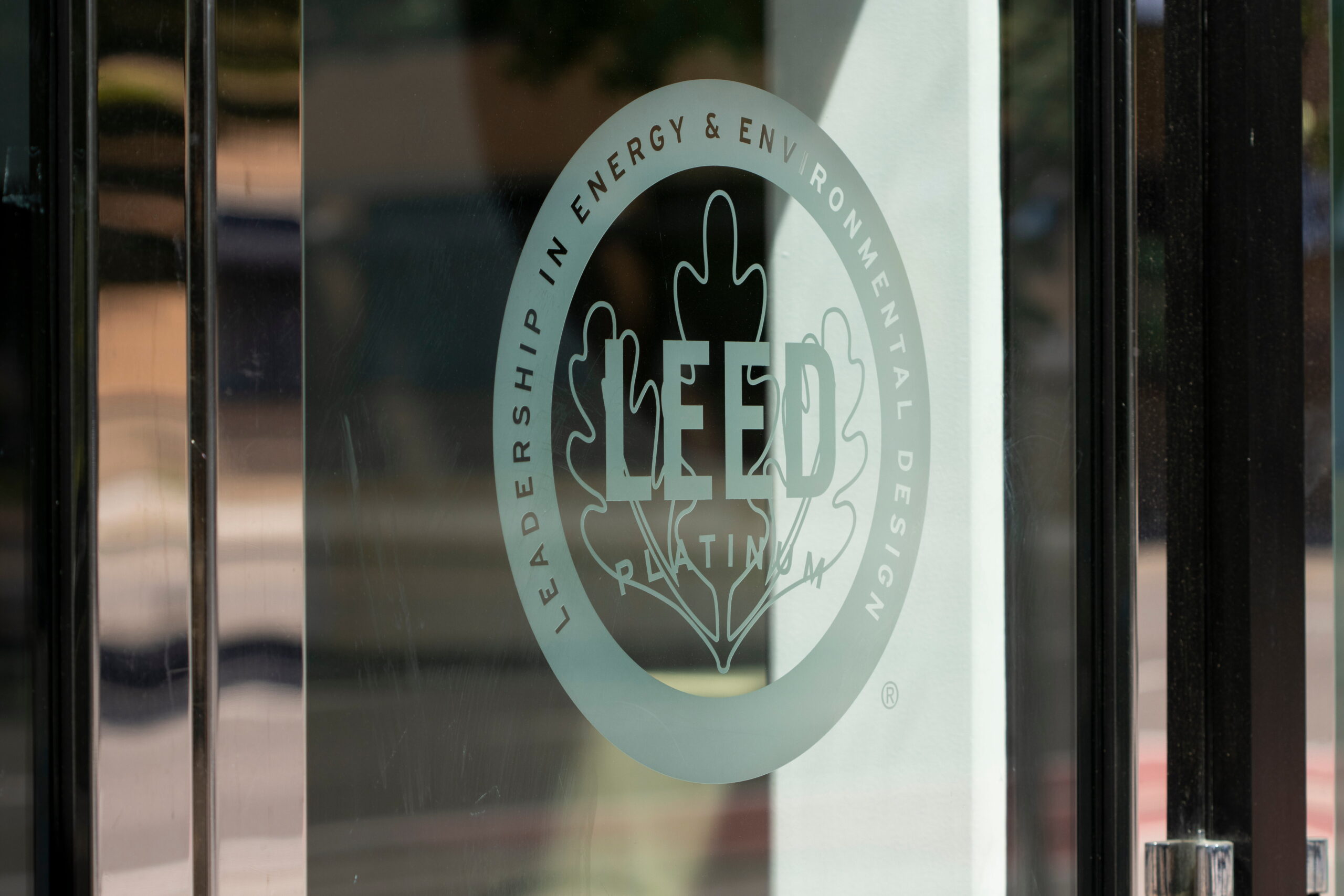 Platinum Leed certification seal on the exterior glass of a commercial building.