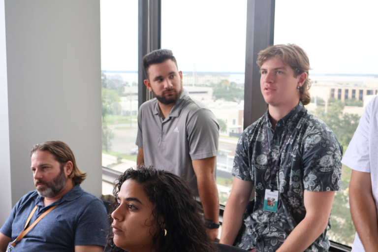 Solcium Team members standing up and listening intently during a team meeting